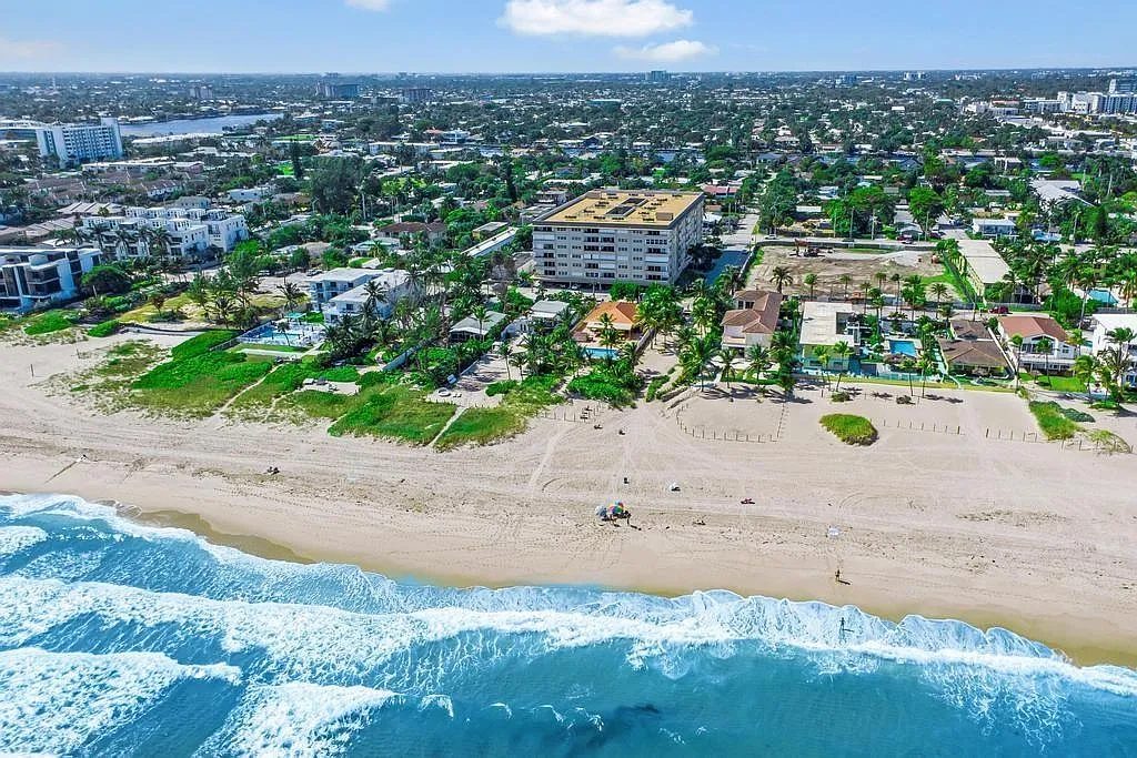 Christopher House from the air, directly on the beach with the surf breaking below it.
