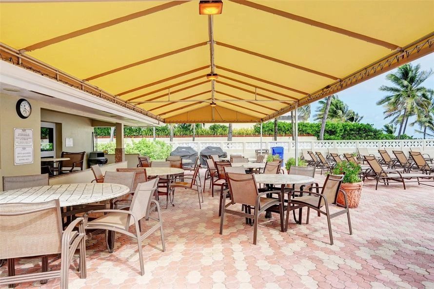 The covered terrace with tables and grills behind the building.